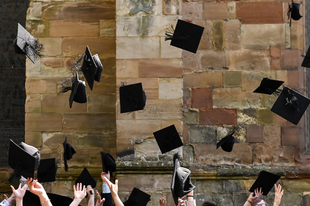 Graduation caps tossed in mid-air, with Worcester Cathedral in the background